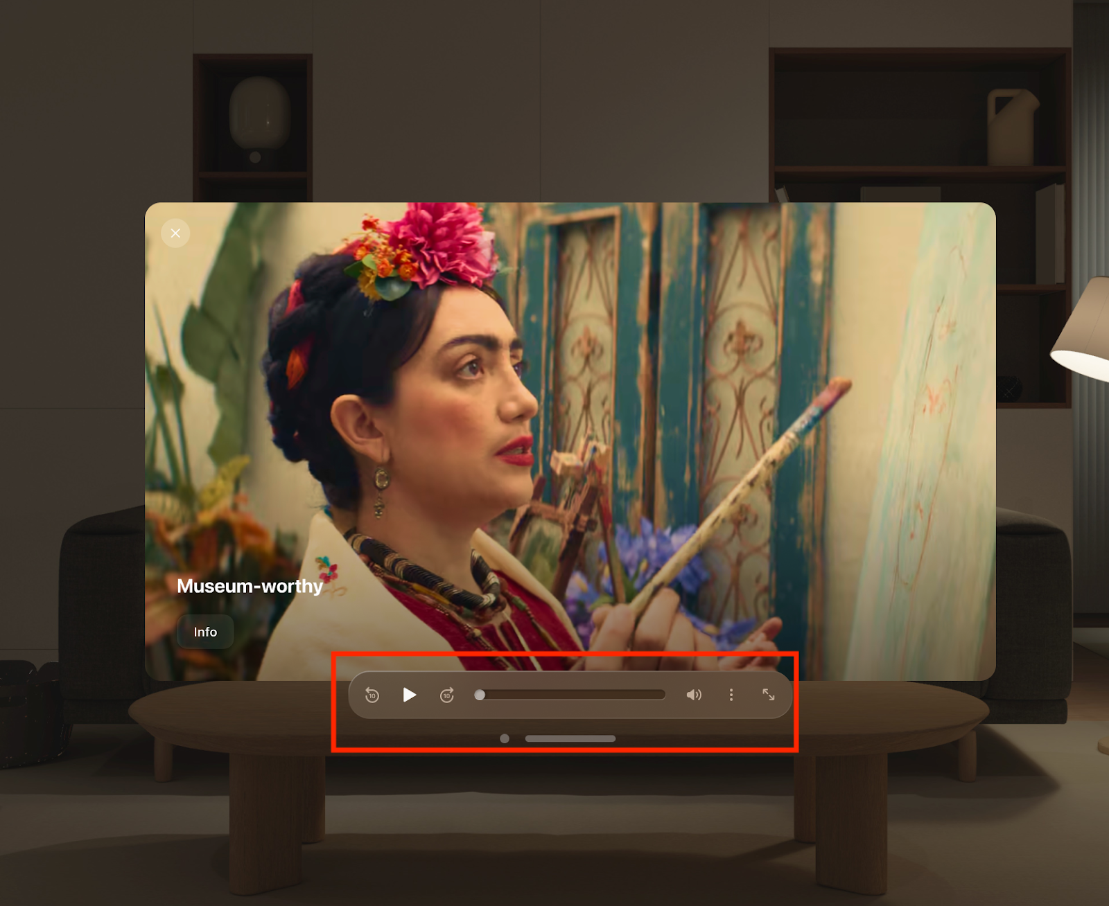 Vimeo's VisionOS video player window displaying a clip of a woman painting with the text "Museum-worthy." A red box highlights the translucent playback control bar floating detached just below the bottom edge of the video frame, which includes buttons for skip back, play, skip forward, a timeline scrubber, volume, and window expansion.